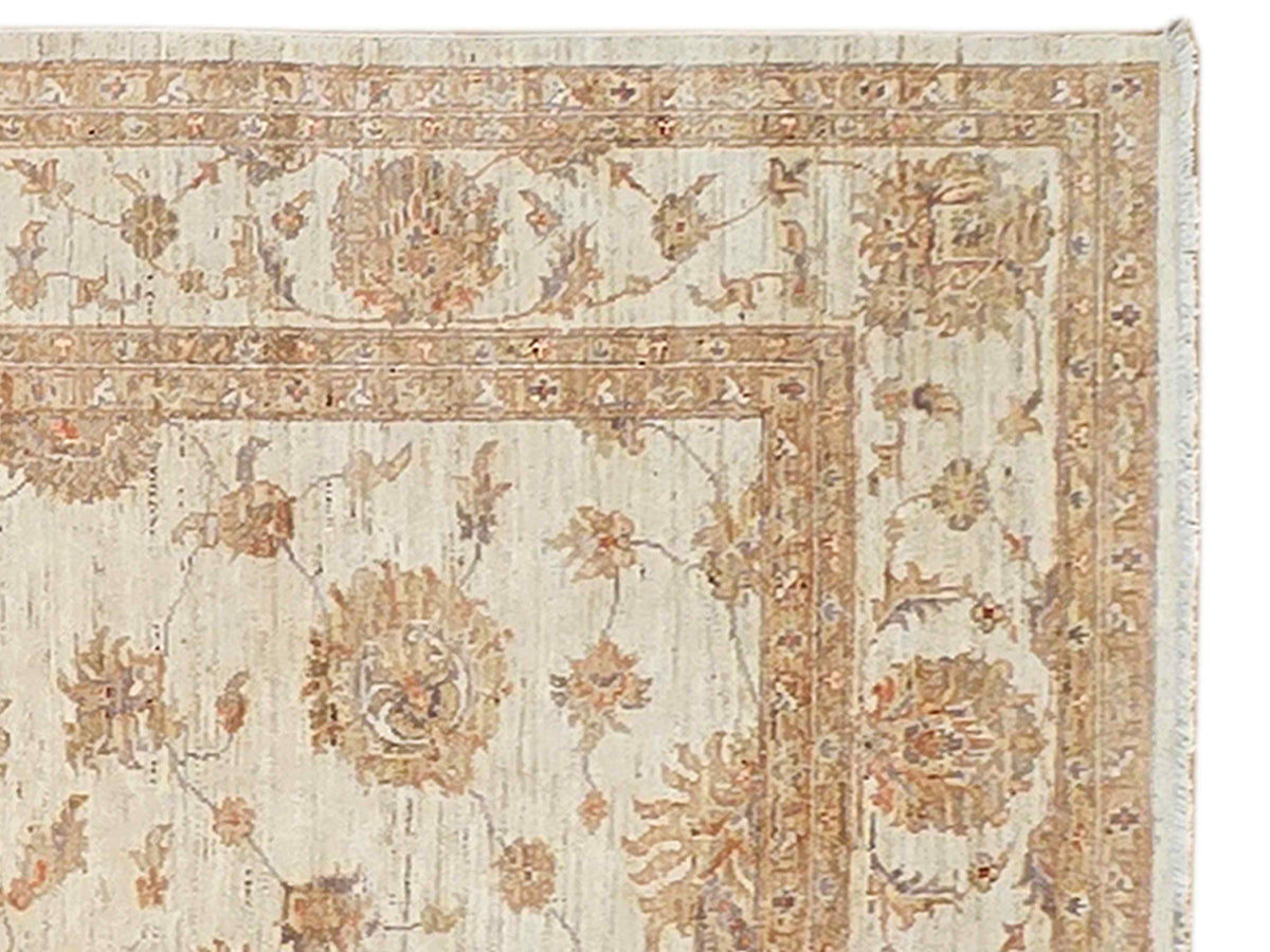 Close-up of cream rug border with rust medallions and distressed floral pattern.