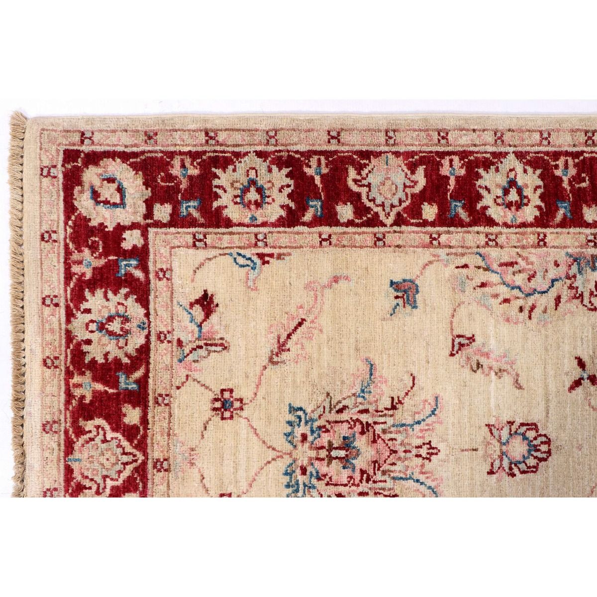 Floral rug corner with cream field, dark red border, and short fringe.
