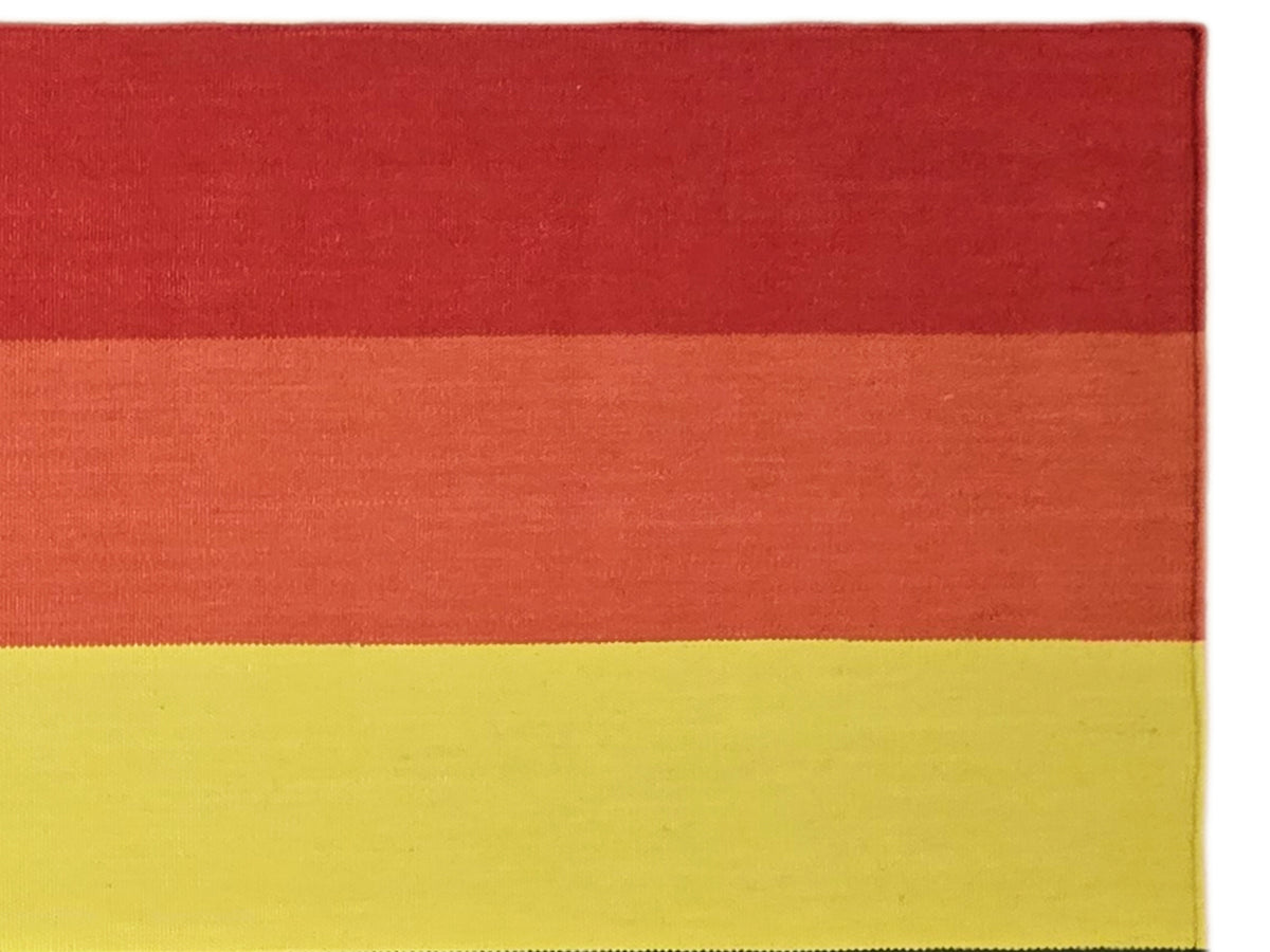 Close-up of striped rug with red, orange, and yellow horizontal bands and textured weave