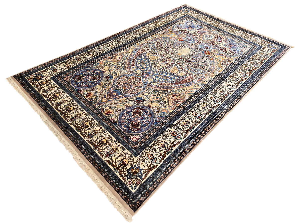 Blue Tabriz-style rug with ornate medallion and border, fringed edges, rectangular area rug.