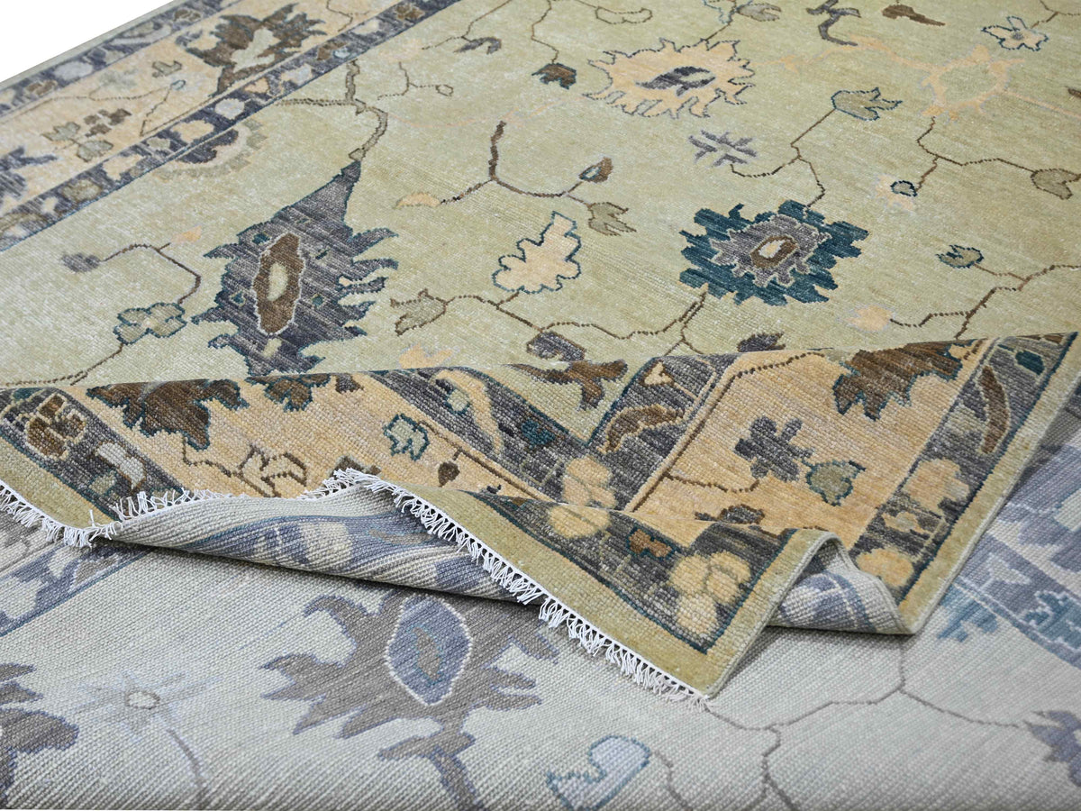 Oushak rug detail showing pile texture, beige base with blue and brown floral elements