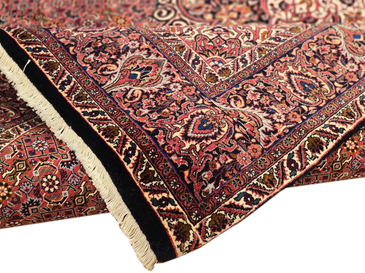 Close-up of terracotta rug corner with navy outlines and cream fringe