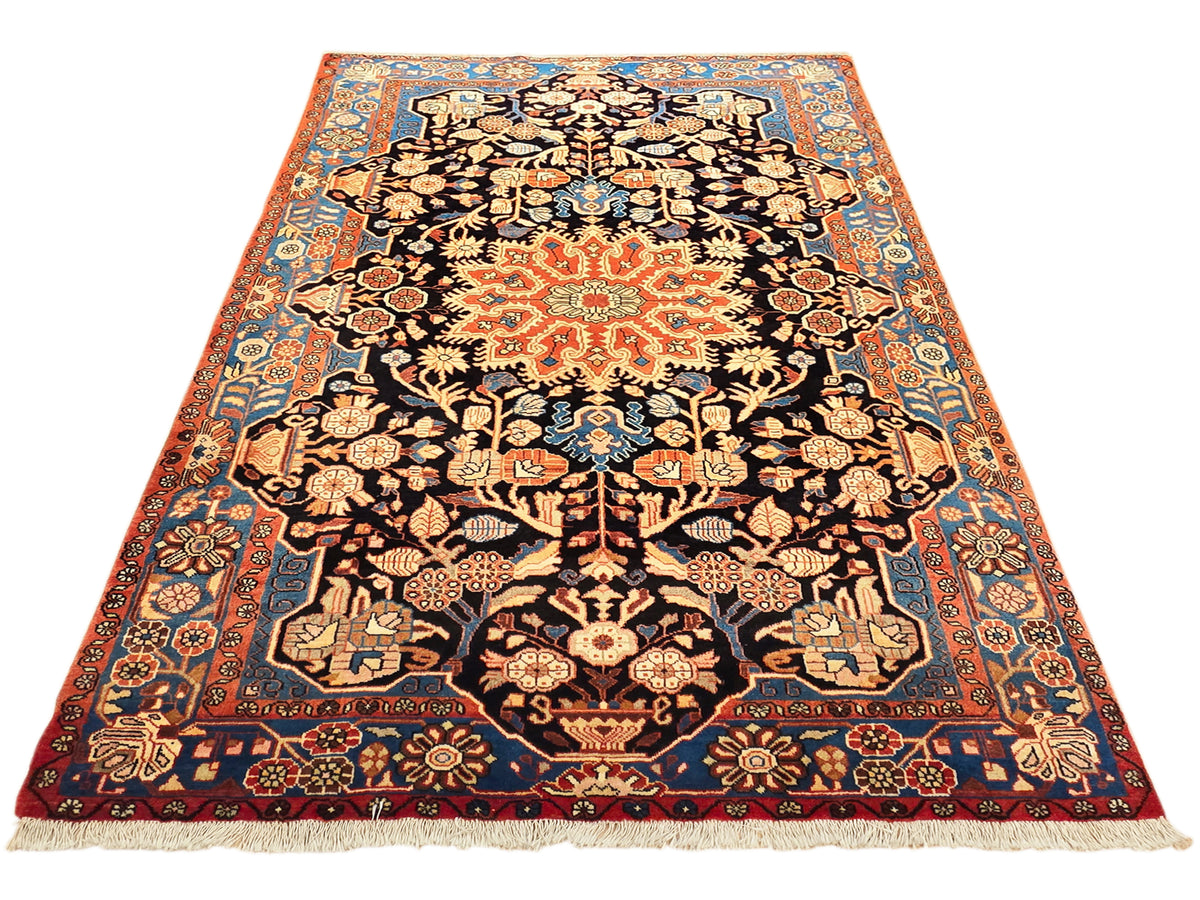 Nahawaand rug with orange border, dark patterned center, multicolor floral vines, short fringe.