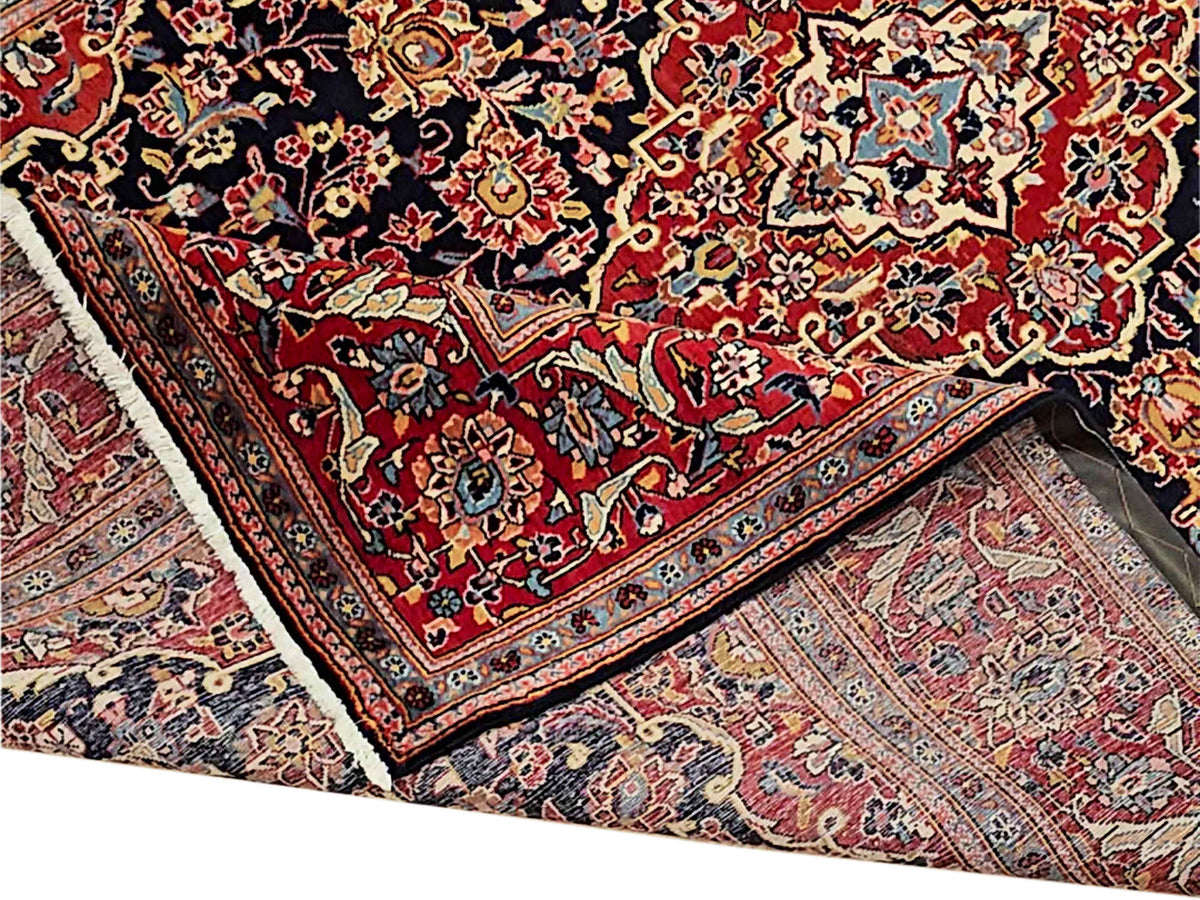 Red, navy, and cream Persian-style area rug with detailed border and central motif.