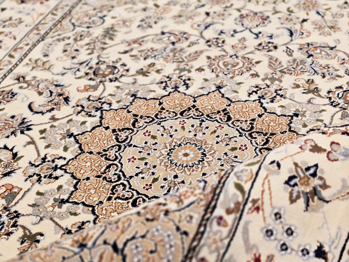 Nain rug close-up: central medallion with brown and navy floral details on ivory background