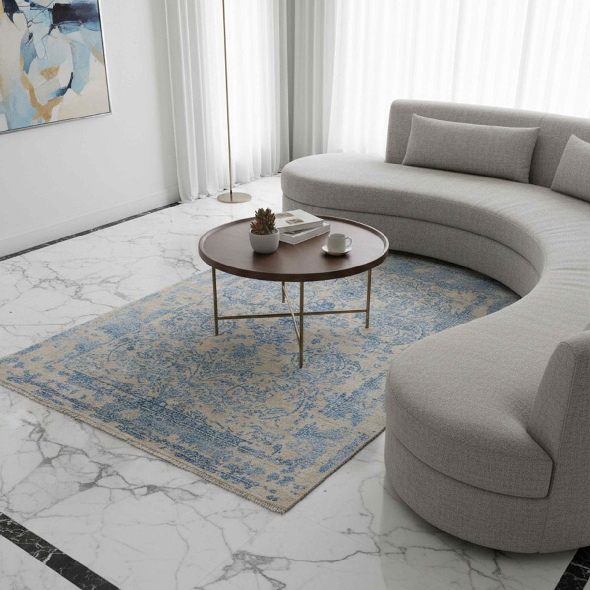Blue abstract patterned area rug on the floor, light beige field with fringed edge.