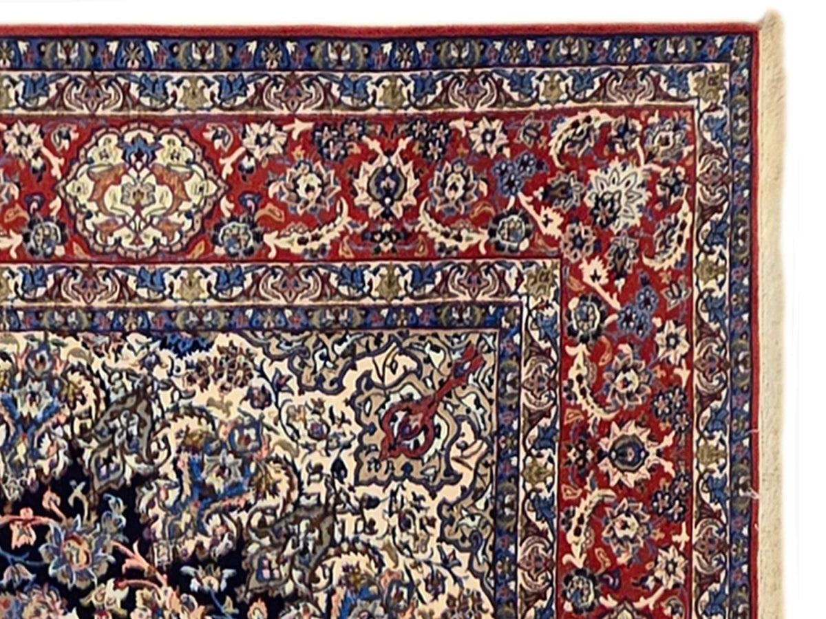 Persian-style rug border with red panels, navy outlines, and cream floral corner medallion
