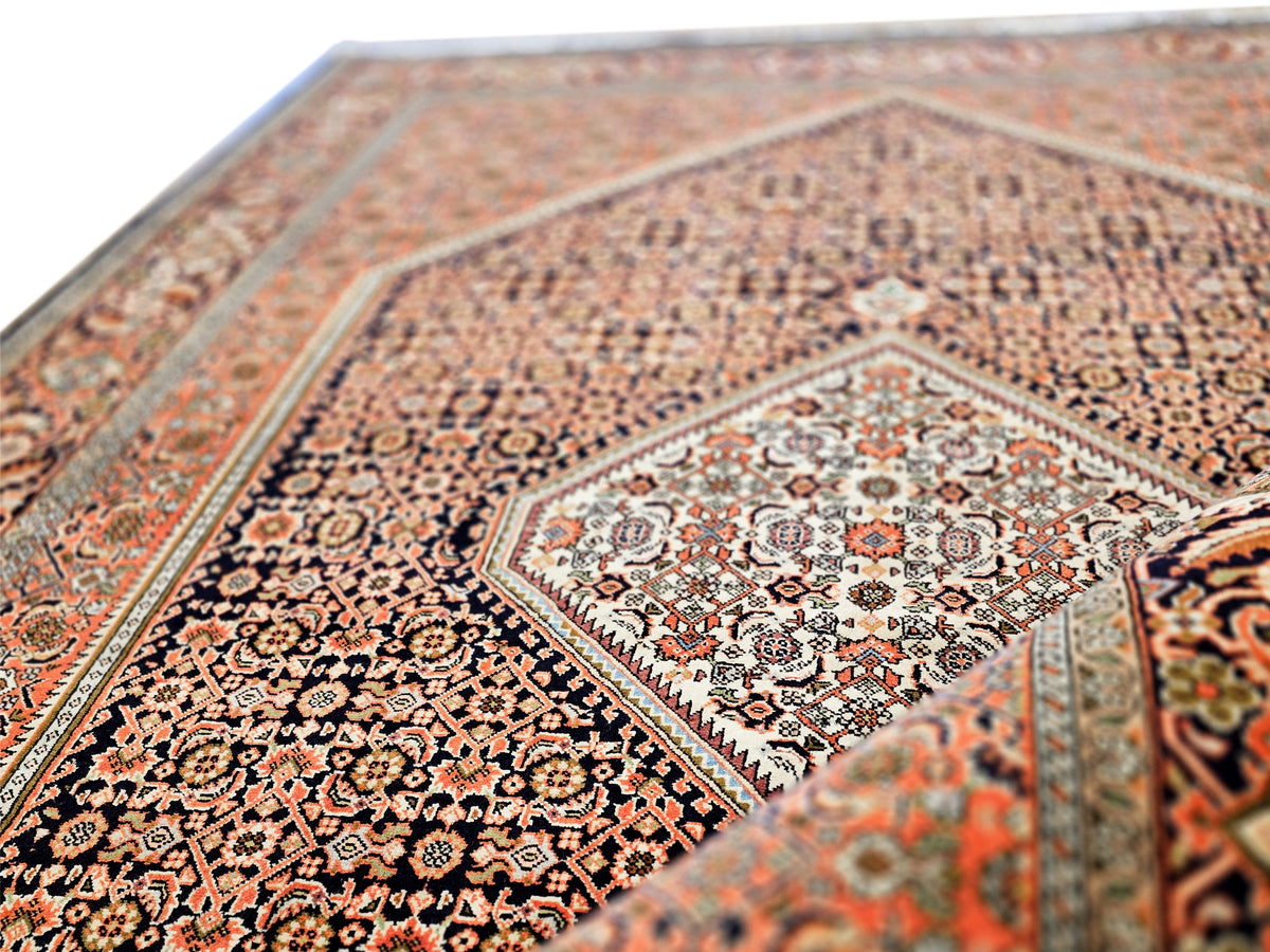 Close-up of detailed rug field with floral motifs in rust, black and cream tones.