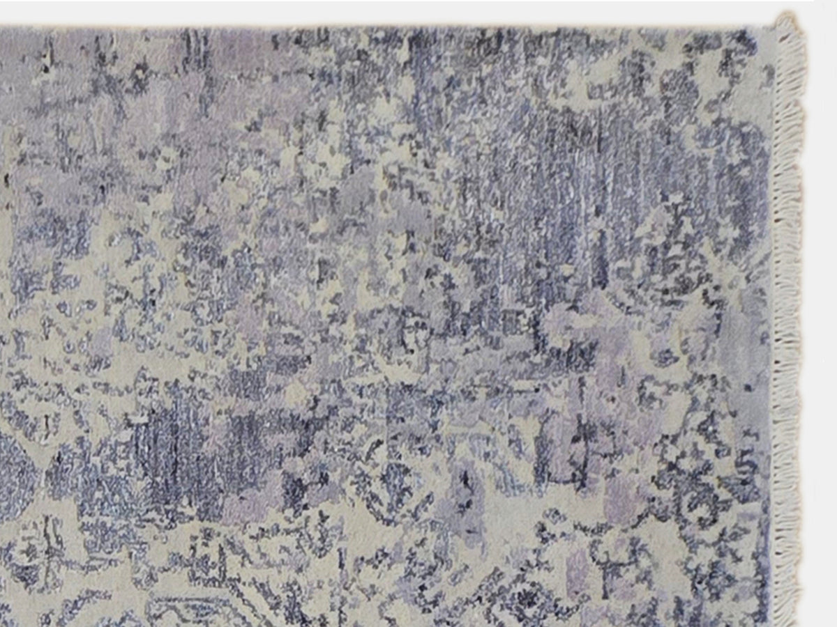 Modern area rug close-up, distressed abstract texture with blue-gray and taupe tones