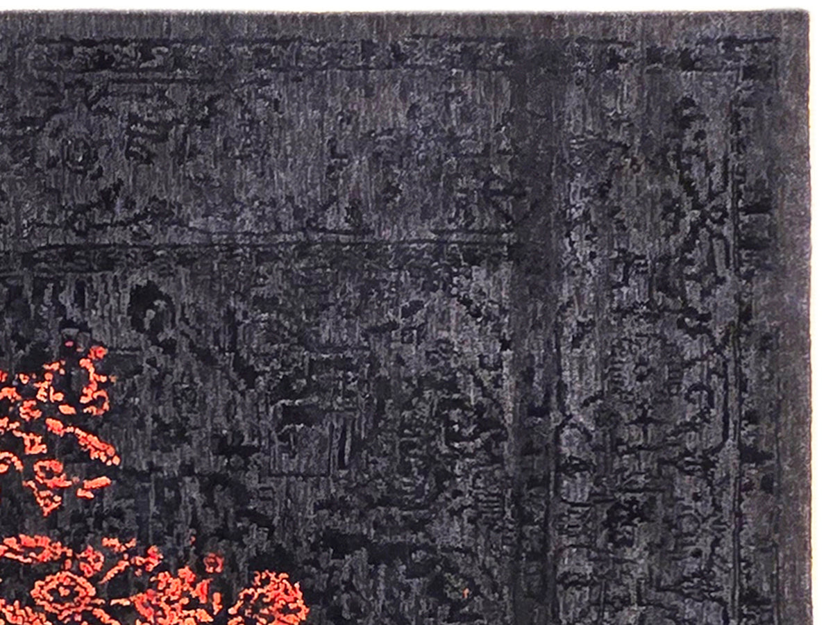 Dark navy rug close-up with embossed texture and orange-red abstract patch