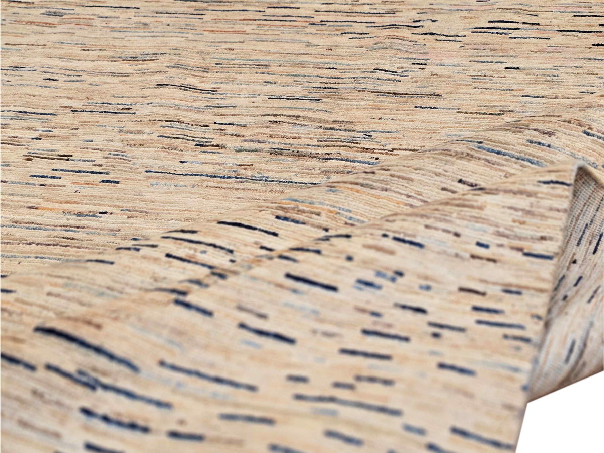 Textured close-up of Streepje Ziegler rug showing beige weave with blue-gray horizontal streaks