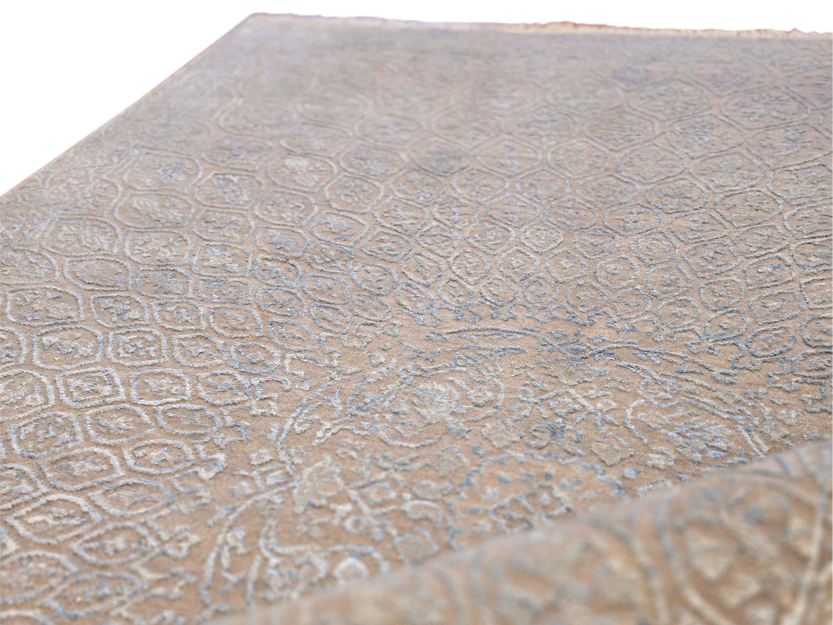 Light blue-gray area rug with ornate floral medallion pattern, textured pile.