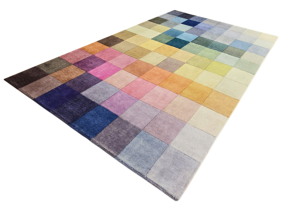 Multicolor square-block rug laid flat, featuring navy, pink, orange, and beige squares