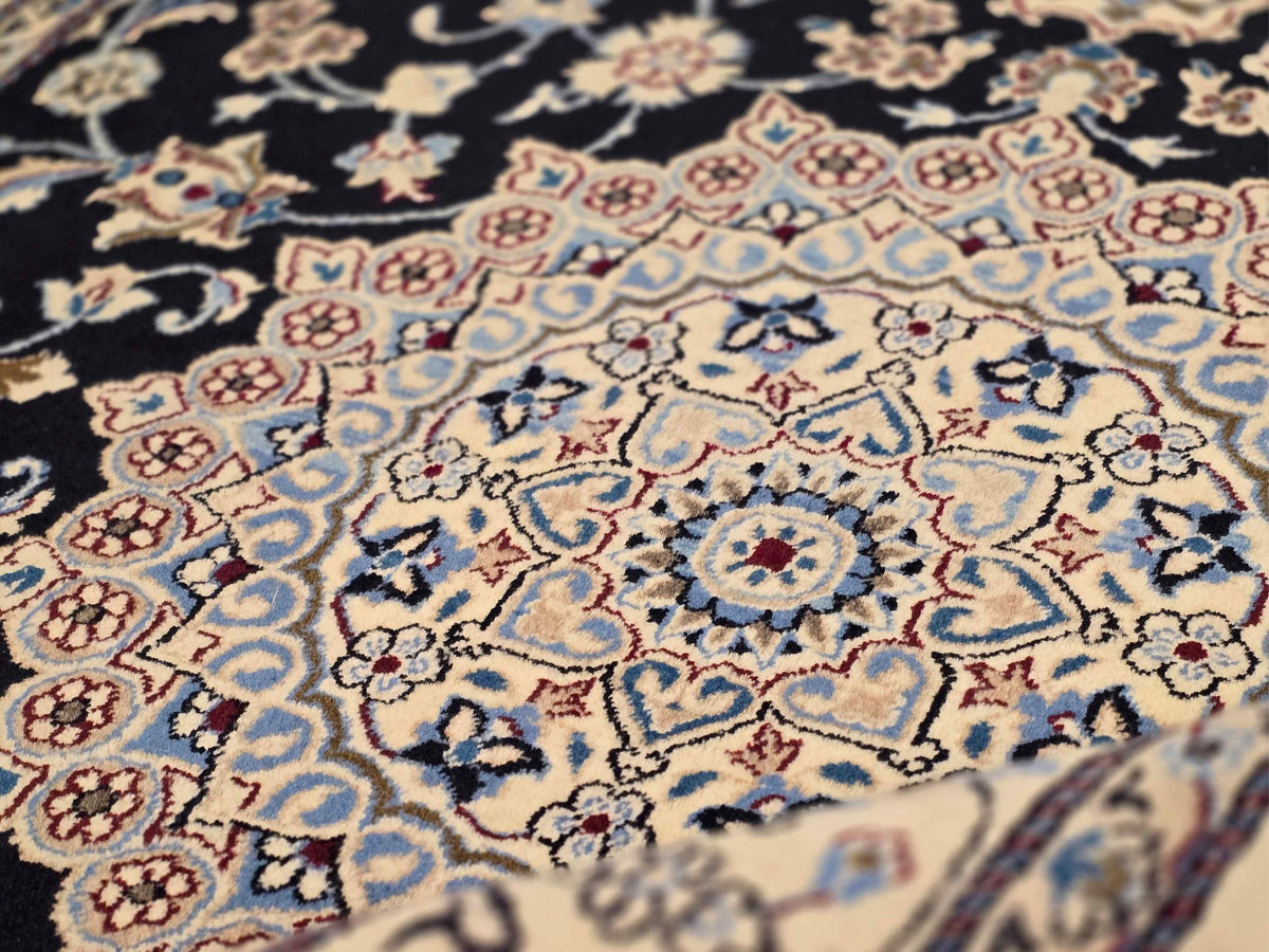 Close-up of Nain rug with light-blue medallions, black field, and multicolor florals