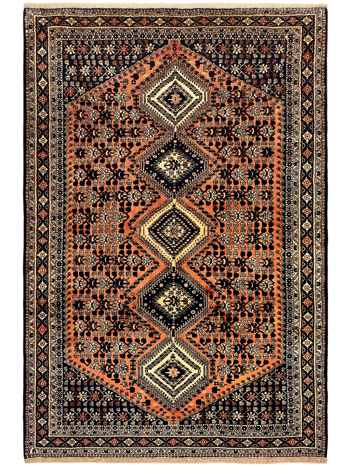 Rectangular orange and dark navy area rug with diamond medallion, ornate border pattern