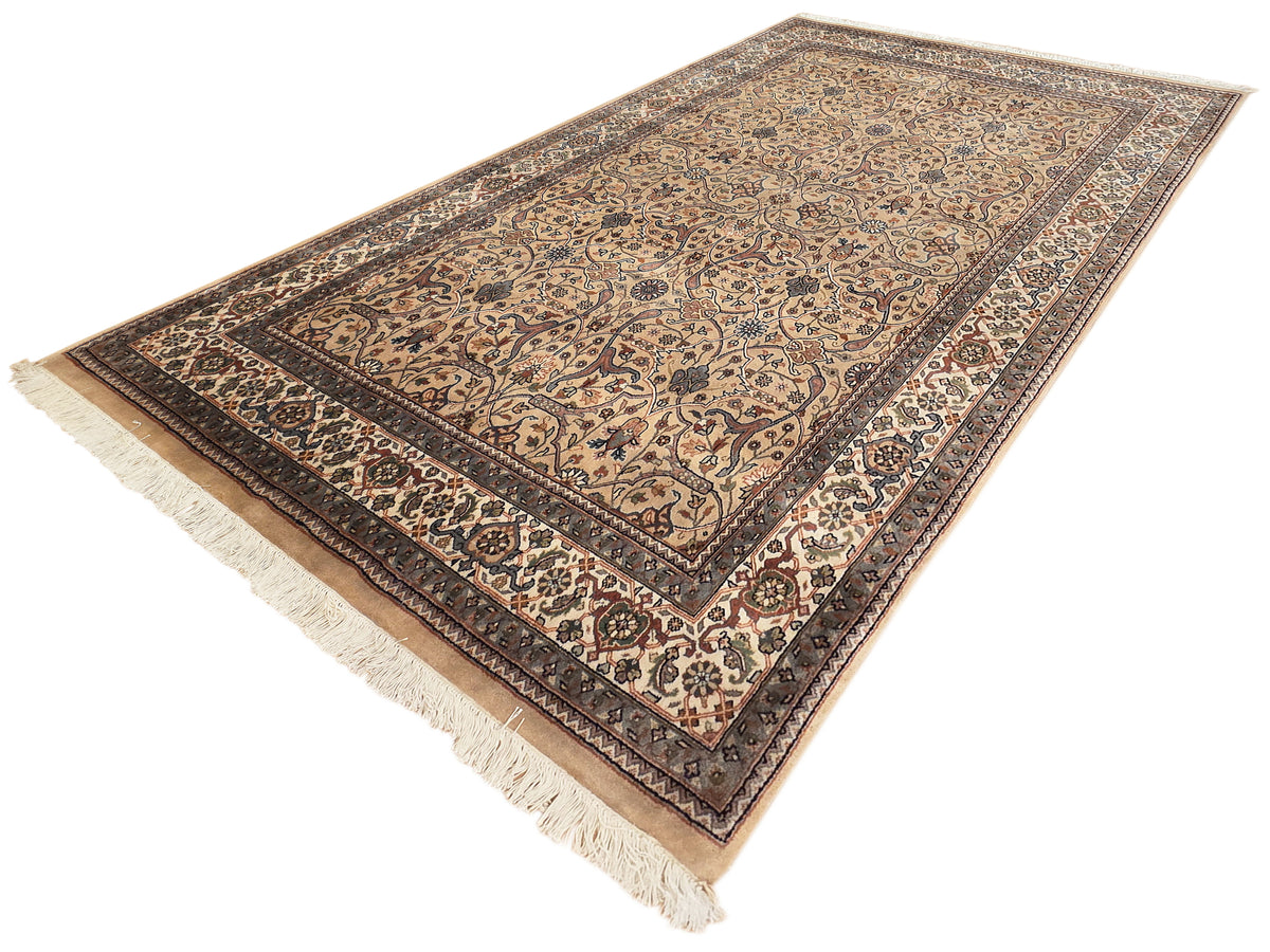 Khashan rug with ornate beige and dark pattern, central panel, and fringes