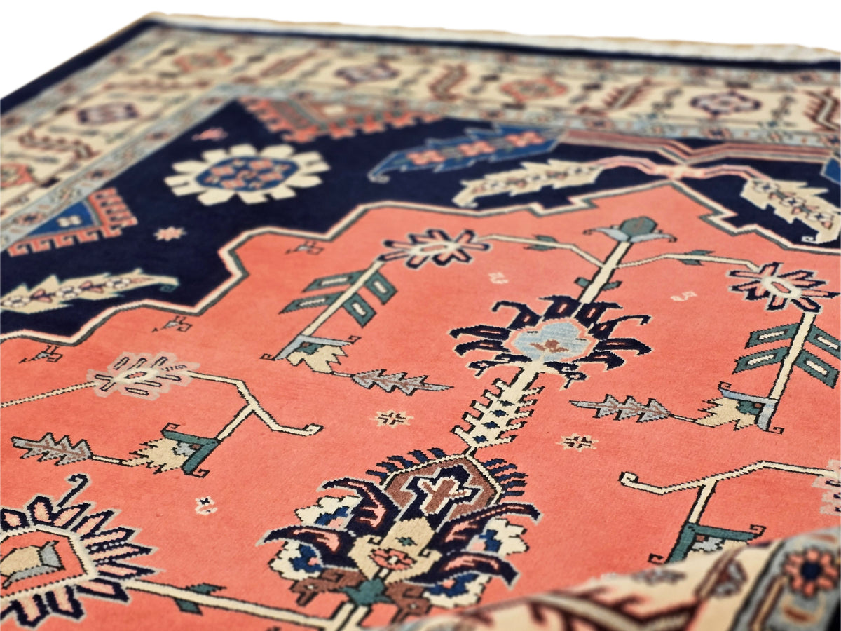 Textured rug with red-orange central field, navy border, and geometric floral motifs