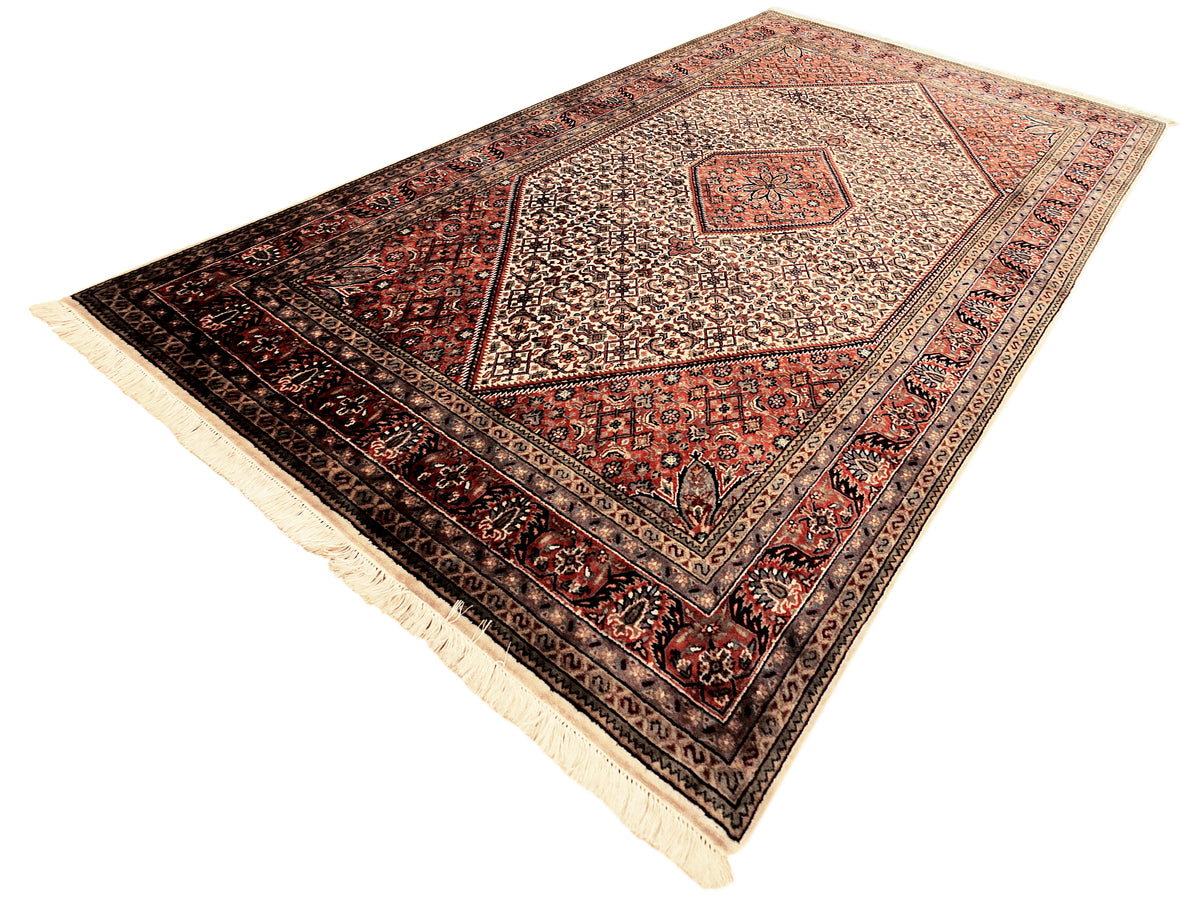 Bidjar rug diamond medallion on cream ground, red and dark navy fields, fringe.