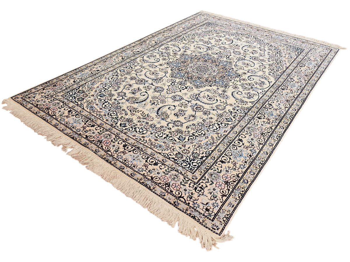 Cream and blue ornate area rug with central medallion, pink accents and fringe