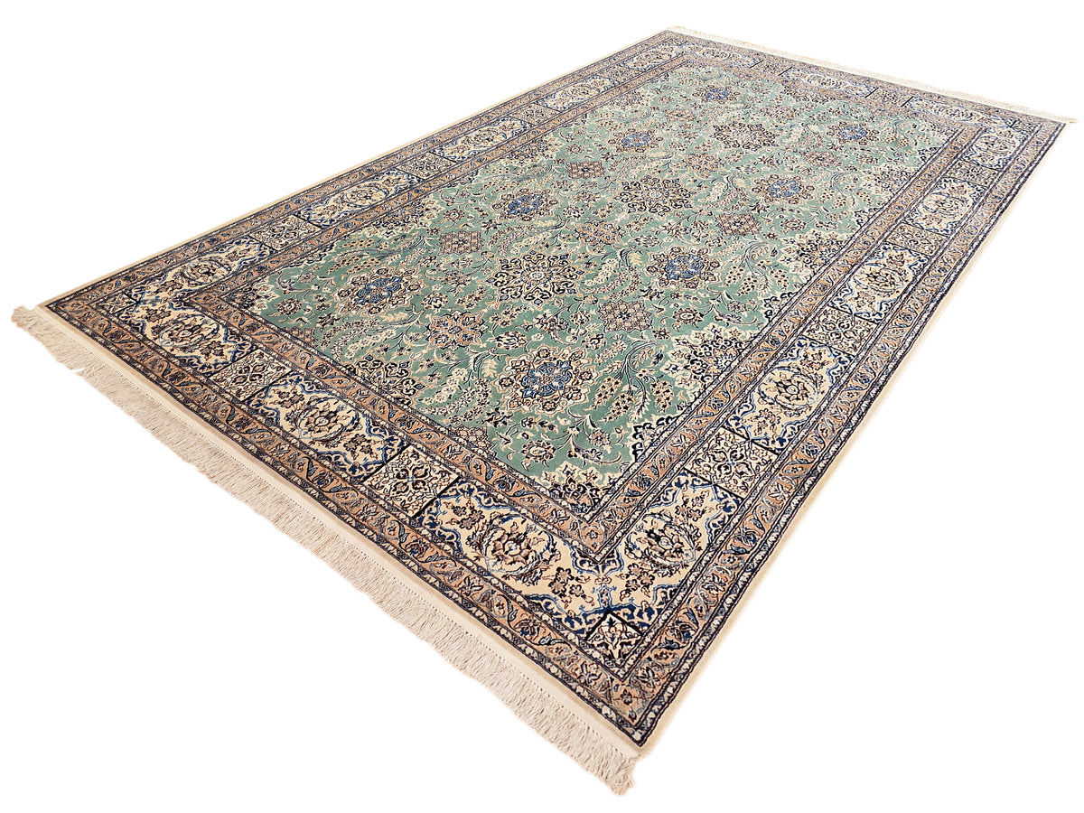 Nain rug with teal floral center, navy and cream border, and off-white fringe trim
