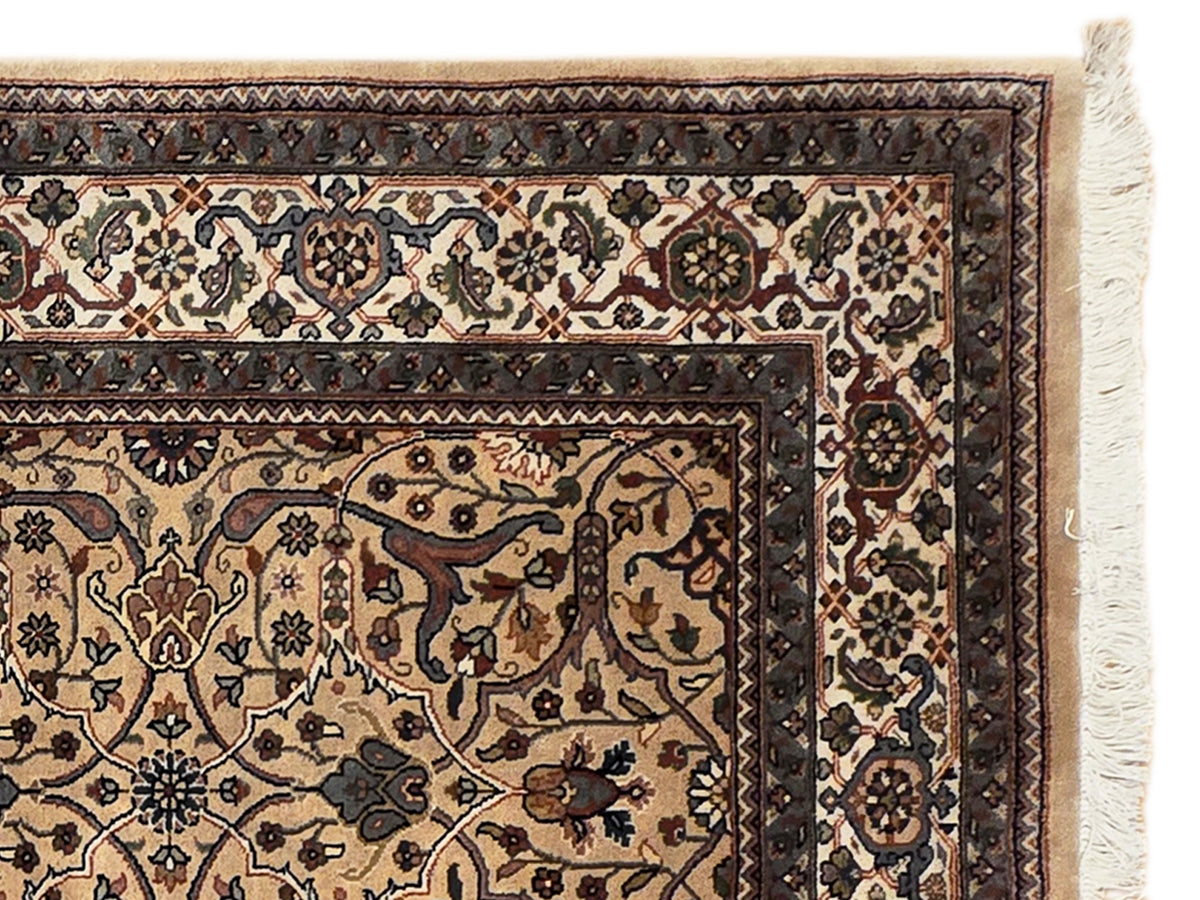 Ornate beige and dark patterned rug with decorative border and fringe