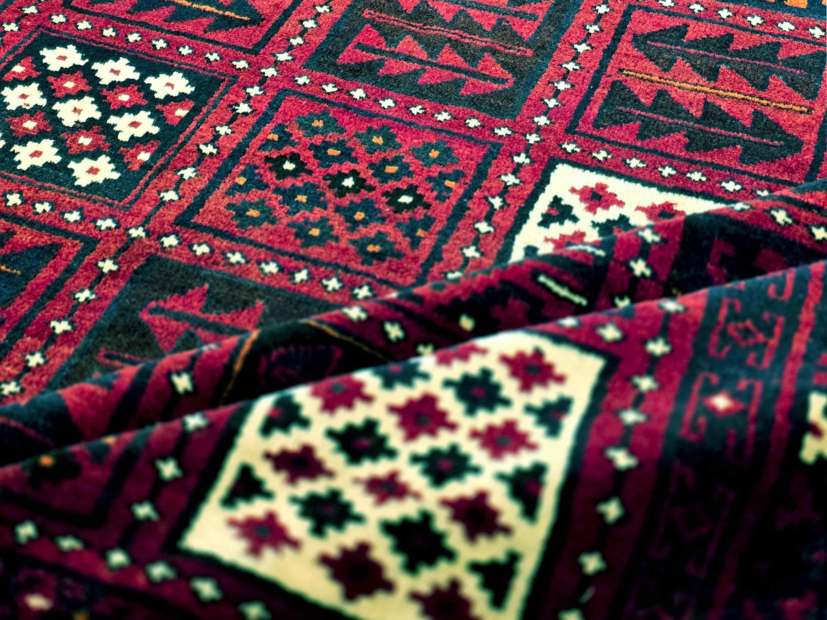 Persian-style rug close-up with dark red geometric blocks, cream medallion, and green accents.