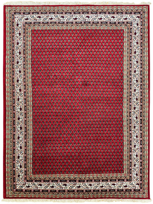 Red central field rug with detailed cream and black border and subtle patterned trim