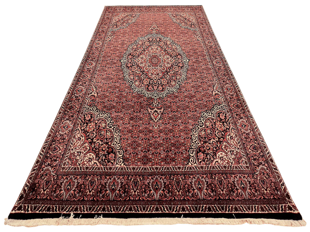 Rectangular terracotta rug with central medallion and dark ornate border