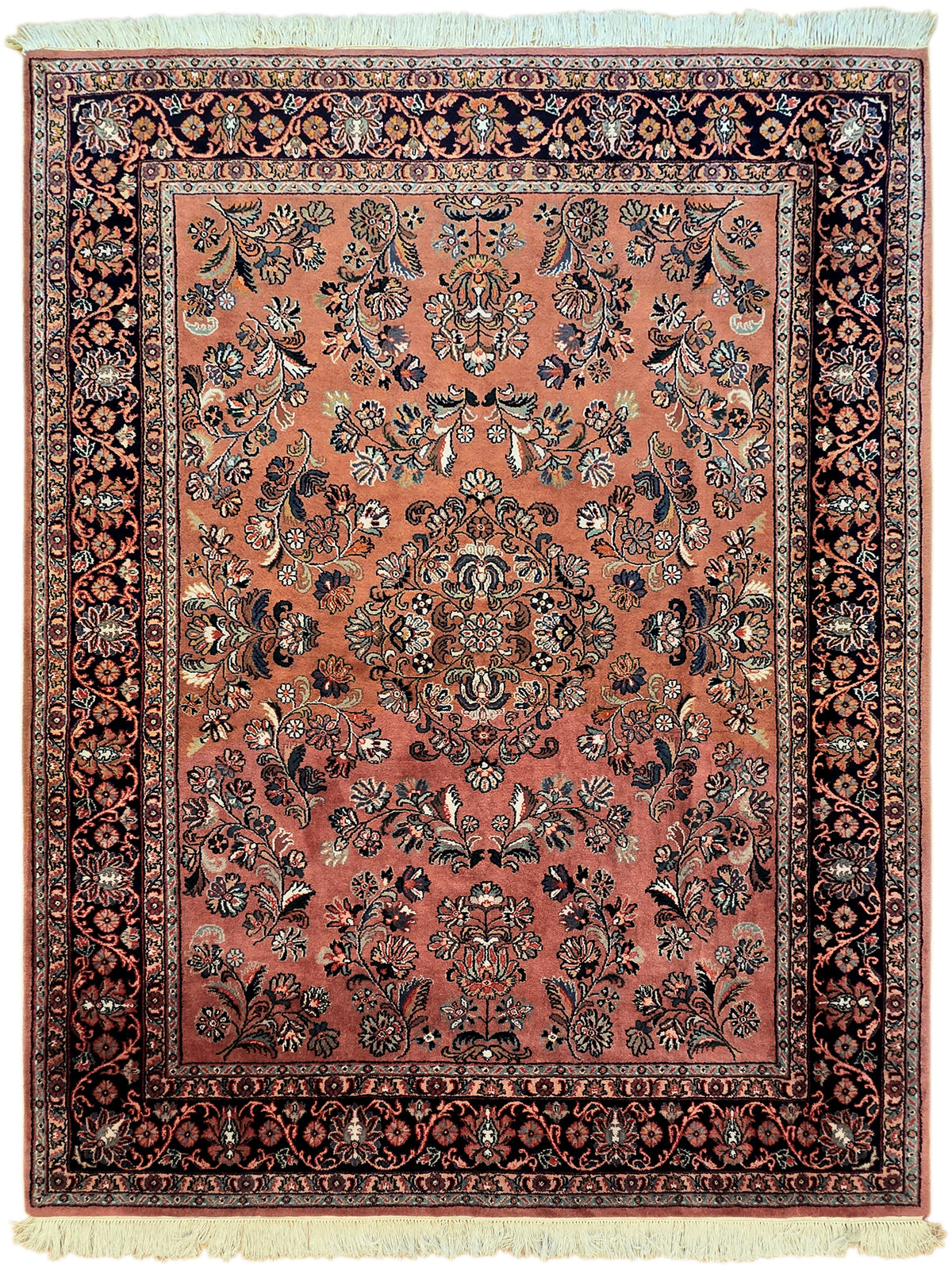 Rust area rug close-up with floral vines, dark border, decorative medallion frame