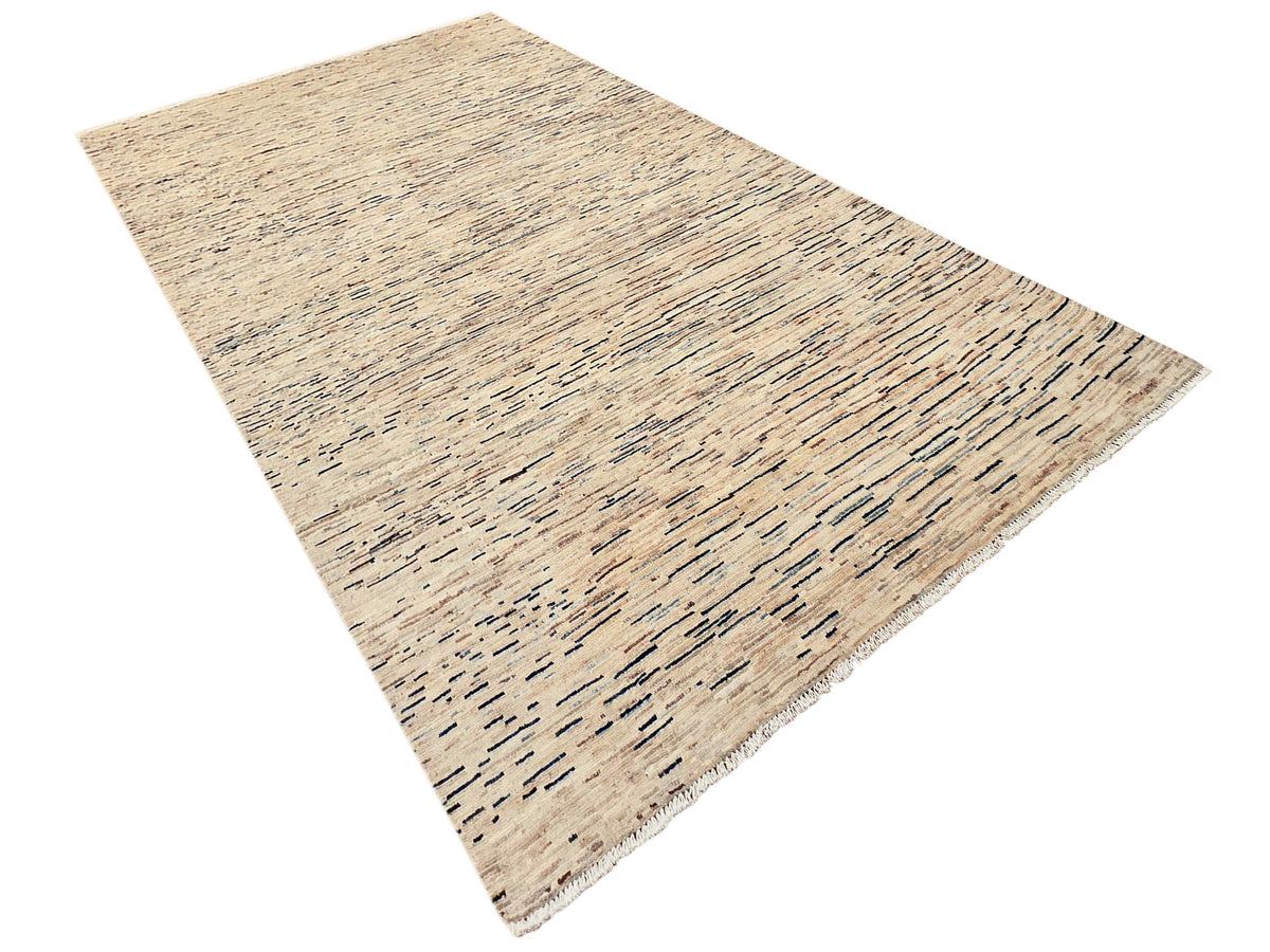 Streepje Ziegler rug angled view with beige ground and blue-gray streaks, fringed border
