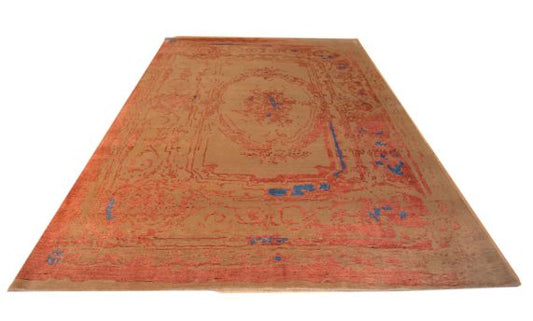 Orange area rug with blue geometric medallion motif, angled view, flat weave.