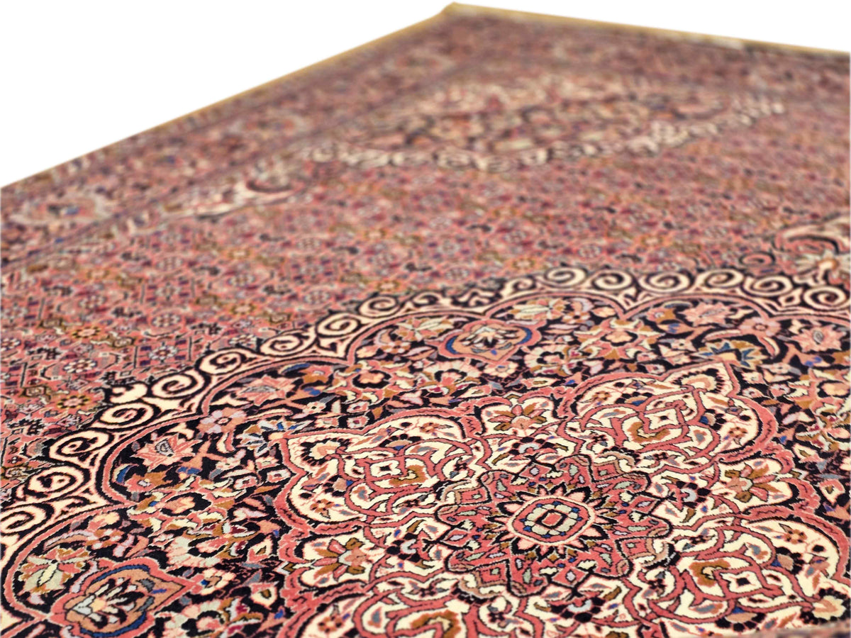 Close-up of terracotta rug with intricate scrolling motifs and patterned center
