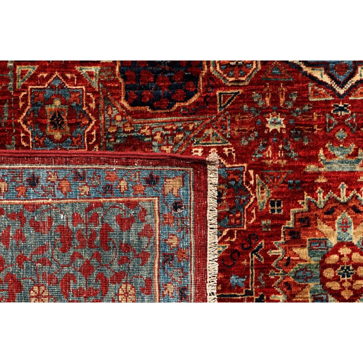 Area rug border detail with red medallion motifs, blue accents, and woven edge
