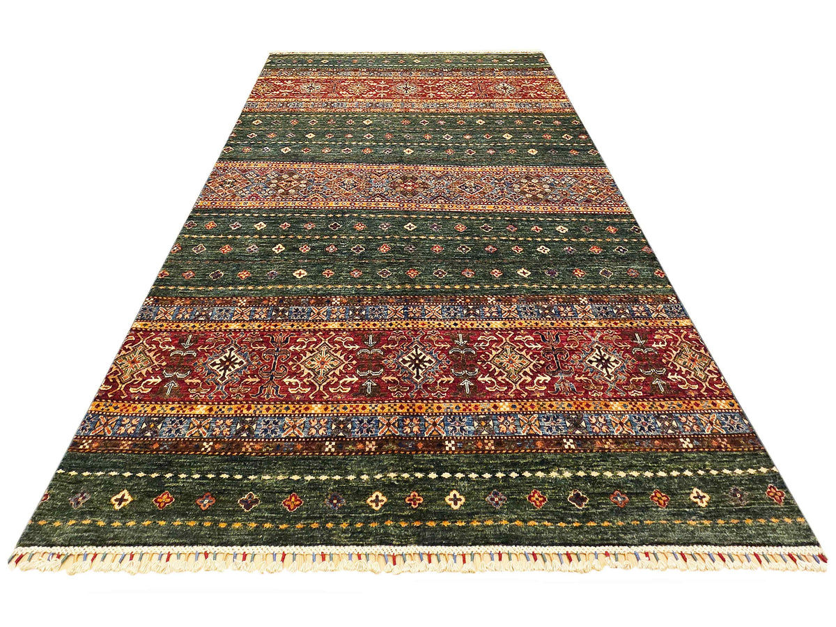 Green and red striped patterned area rug with geometric borders and cream fringe