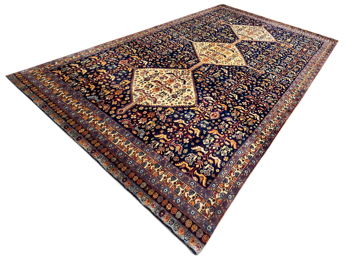 Dark navy patterned rug with cream diamond medallion and multicolor floral border