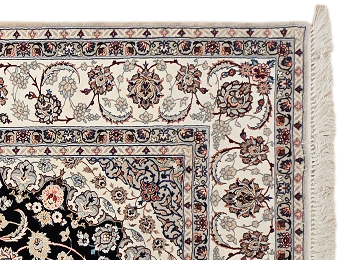 Isfahan rug detail: ivory floral scrolls with navy-red accents and textured border fringe