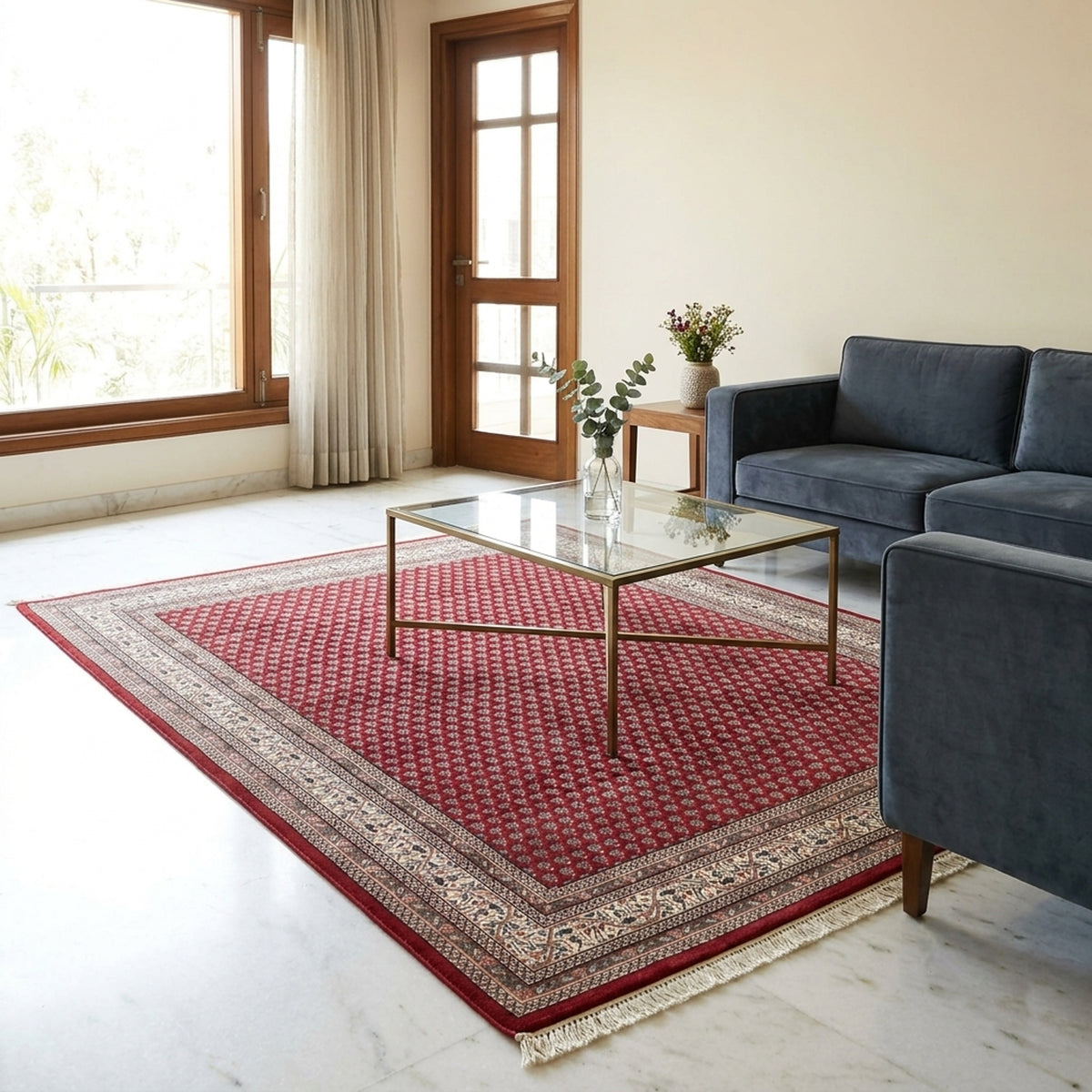 Red area rug with geometric pattern, cream border, and short fringe on floor.