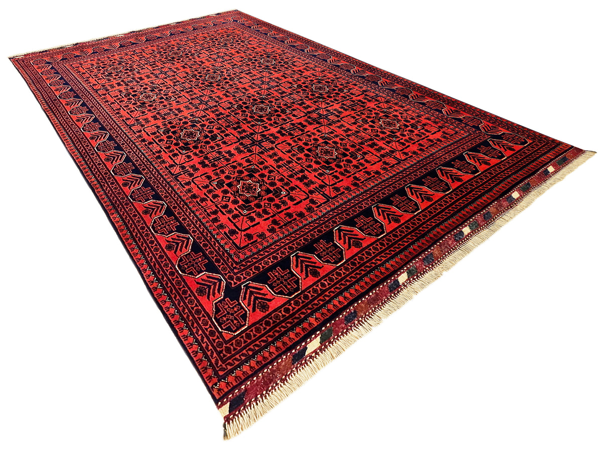 Red geometric rug with navy border and beige fringed corners