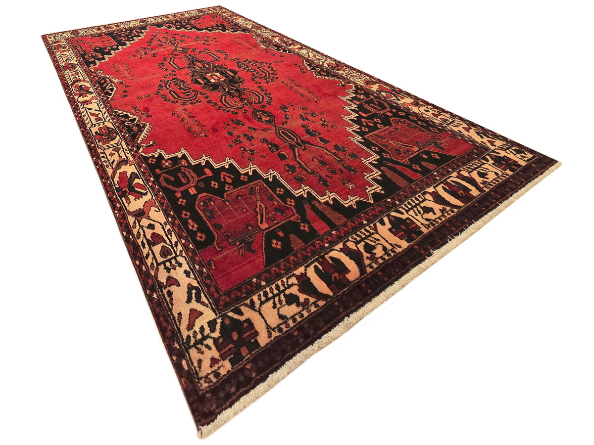 Red patterned area rug with ornate medallion and geometric border in beige and black