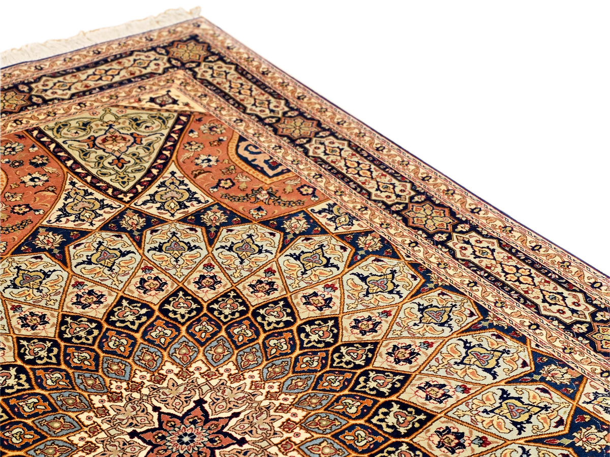 Close-up of ornate Tabriz rug pattern with floral motifs and navy, rust, and cream