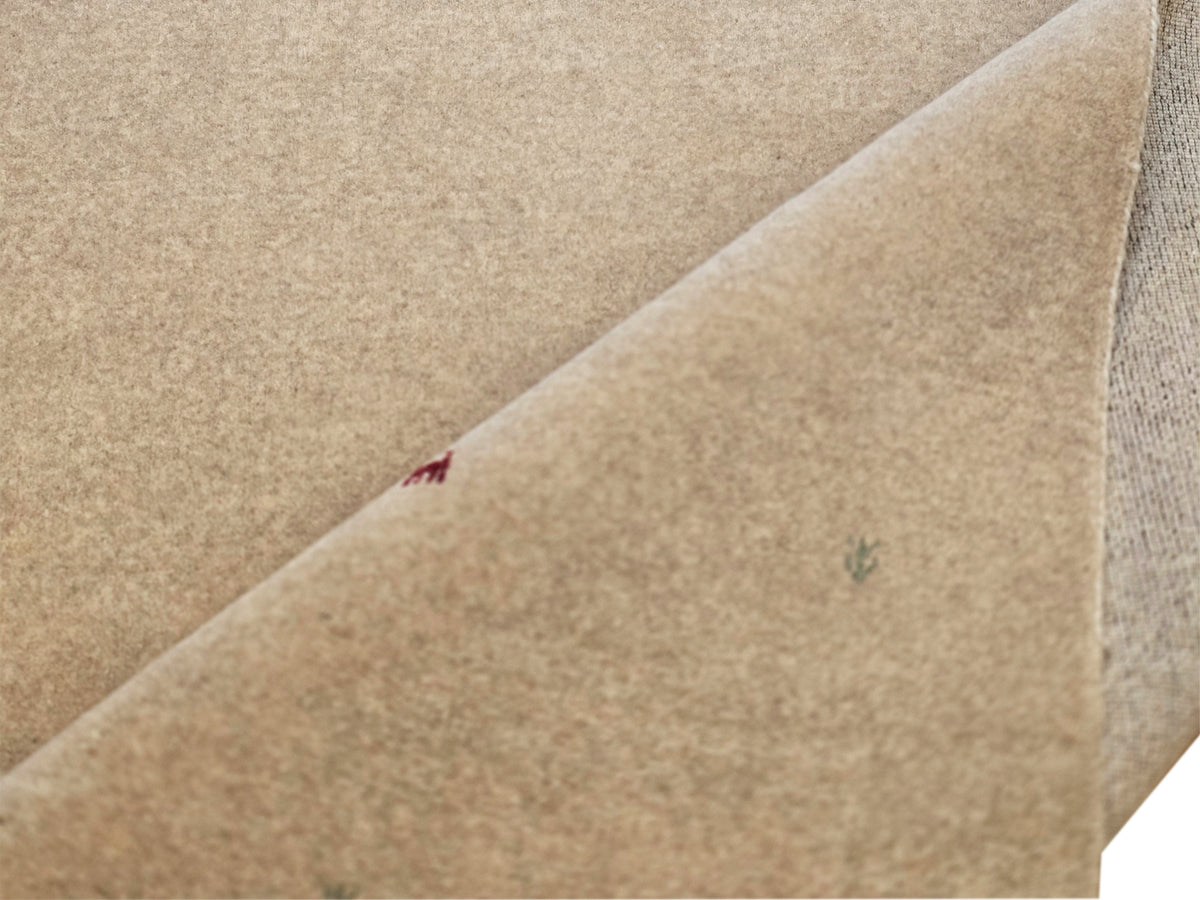 Beige handloom rug folded corner detail, multicolor motifs, flatwoven surface