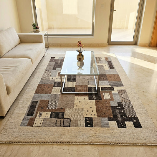 Large patchwork rug with beige field, brown, gray, and black geometric blocks