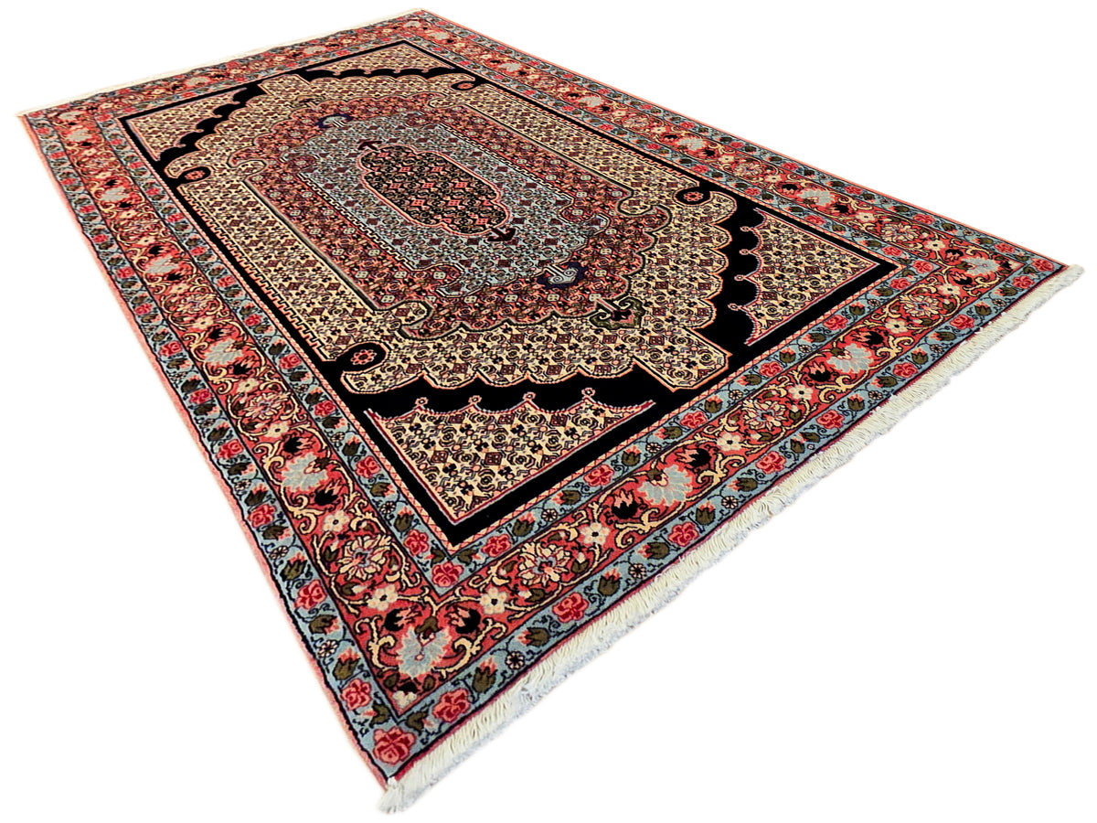 Rectangular area rug with ornate border in red, navy, and cream; corner medallion.