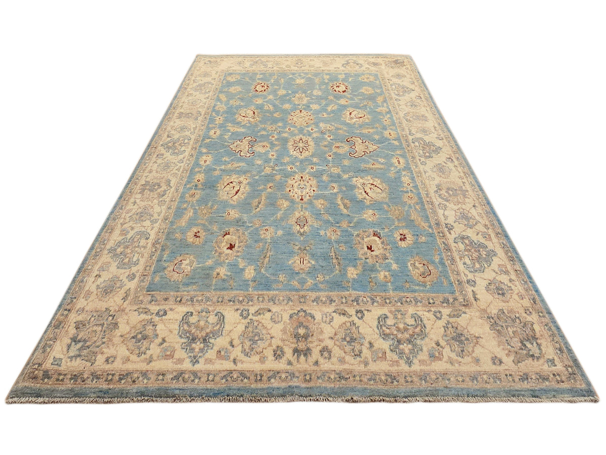 Light blue and beige vintage-style area rug with central medallion and border